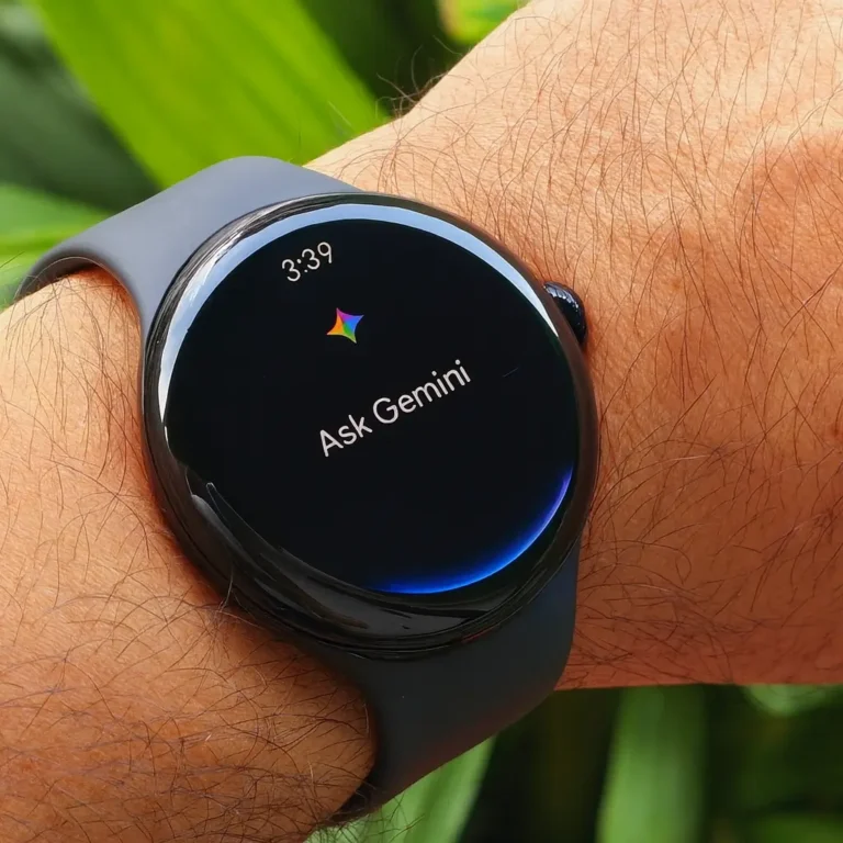 Pixel Watch 4 with Gemini Assistant interface on wrist, showing the time 3:39 and sleek black display with curved edges, worn with a dark silicone strap.